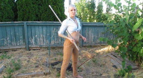 Bald female Abigail Dupree strips and takes a piss while hoeing the garden