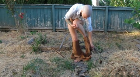 Bald female Abigail Dupree strips and takes a piss while hoeing the garden