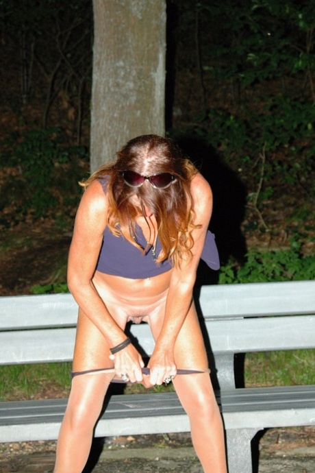Amateur female pulls down her hose for a piss on park bench at night