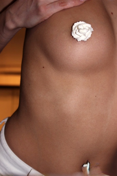 Brunette teen Andi Land covers herself in whipped cream while disrobing