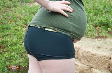 Pregnant girl holds a sex toy while showing her hairless vagina
