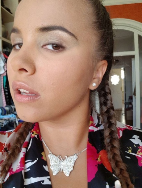 Young looking Latina girl Olivia hides her huge tits while taking selfies
