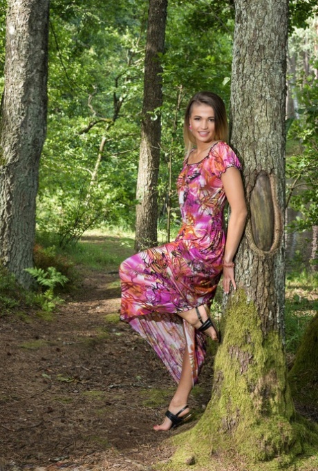 Teen model Zora A highlights her bald slit while naked in a forest