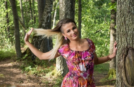 Teen model Zora A highlights her bald slit while naked in a forest