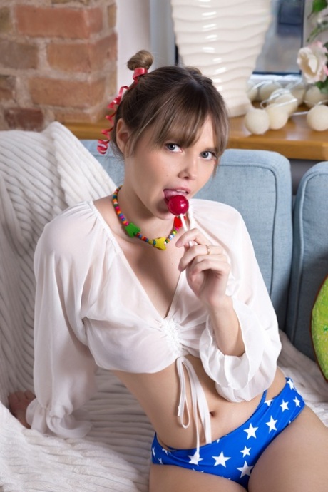 Beautiful young girl Marciana sucks on candy while freeing her hot body