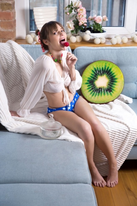 Beautiful young girl Marciana sucks on candy while freeing her hot body