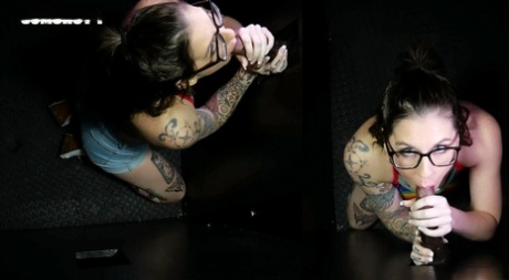 Tattooed brunette Nikki Zee sucks off a bunch of cocks at a gloryhole