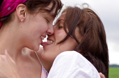 Young chicks Gina J and Immie tongue kiss and lap hairy pussy outside
