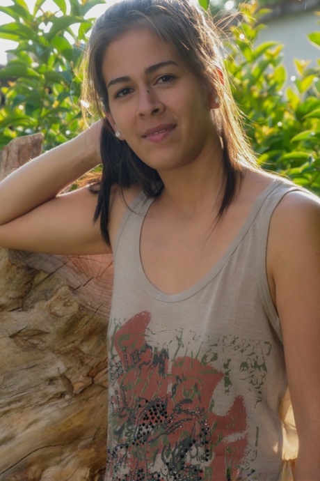 Young brunette Solange exposes her attributes and hairy vagina in the park