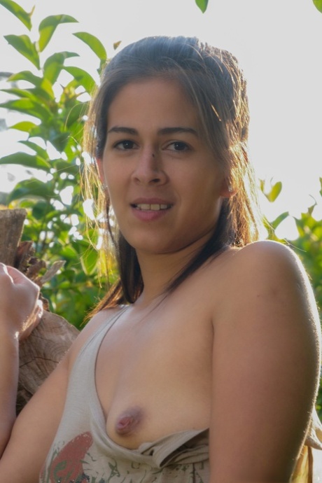 Young brunette Solange exposes her attributes and hairy vagina in the park