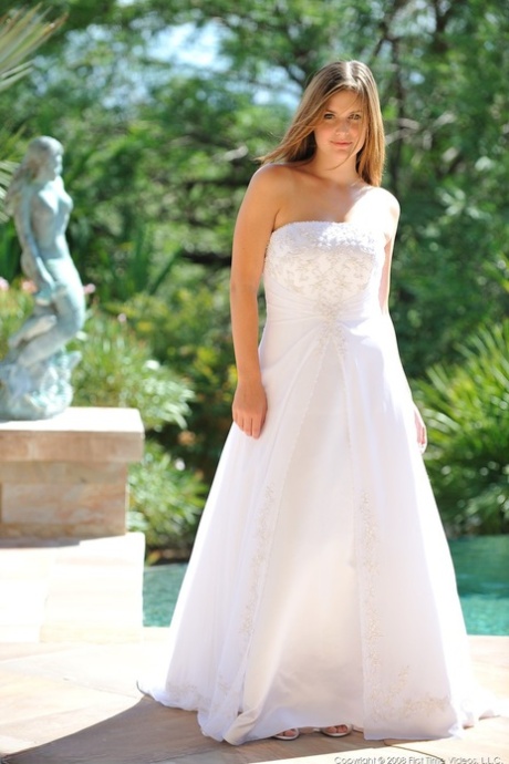 Busty glamorous amateur Danielle models wedding gown indoors  by the pool