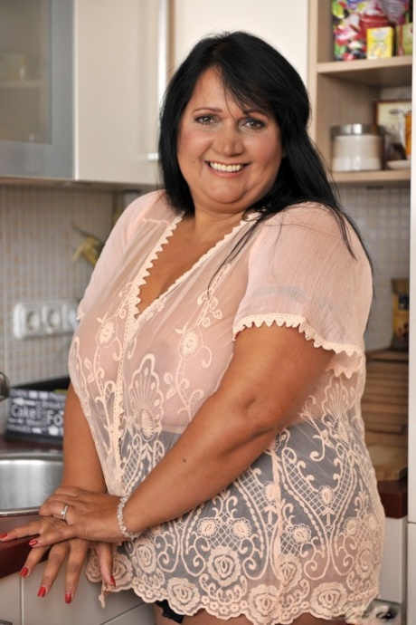 BBW brunette Bubi poses and displays her big natural tits in a kitchen