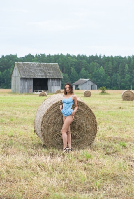 Belarusian cutie Slava stripping and posing buck naked in a hay field