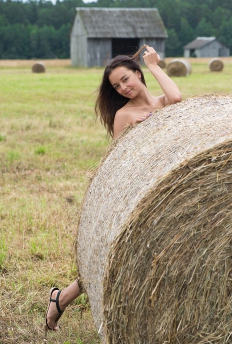 Belarusian cutie Slava stripping and posing buck naked in a hay field