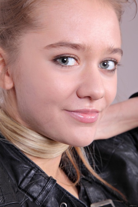 Charming teen Sara B exposes her little bush while teasing in a leather jacket