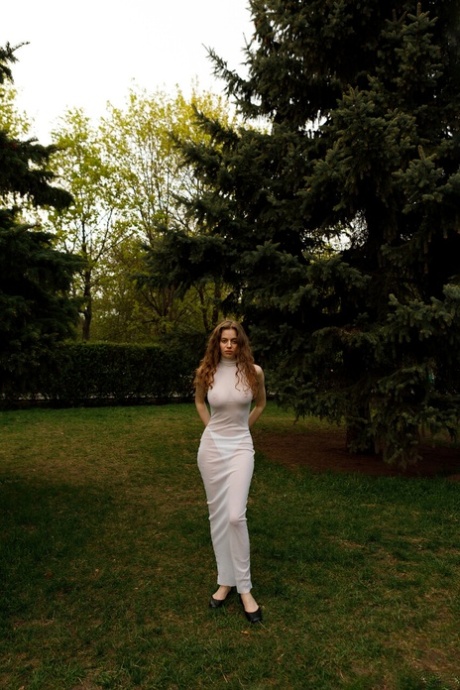 Beautiful braless amateur babe with big tits posing in her white dress outside